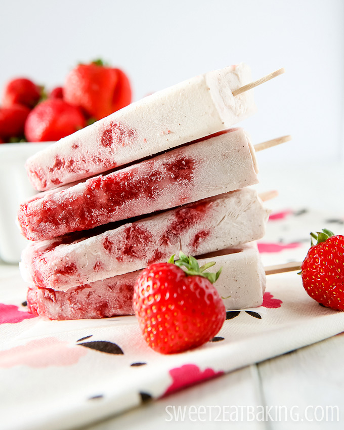 strawberry coconut popsicles stacked on a floral napkin
