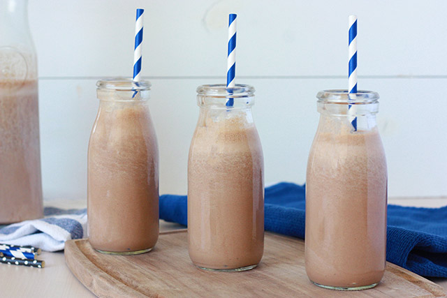 homemade chocolate milk in milk bottles with blue and white striped straws