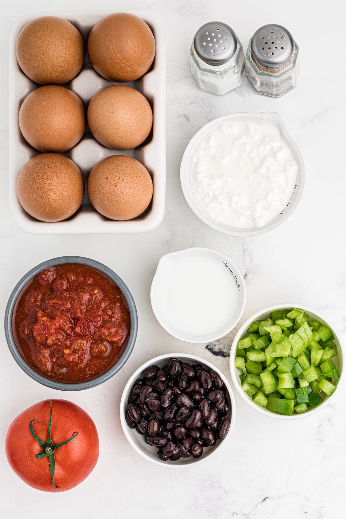 ingredients for spanish egg cups with salsa, tomato, black beans, green bell peppers