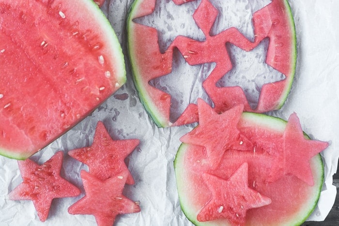 Cutting watermelon stars for a healthy red white and blue themed infused water for the 4th