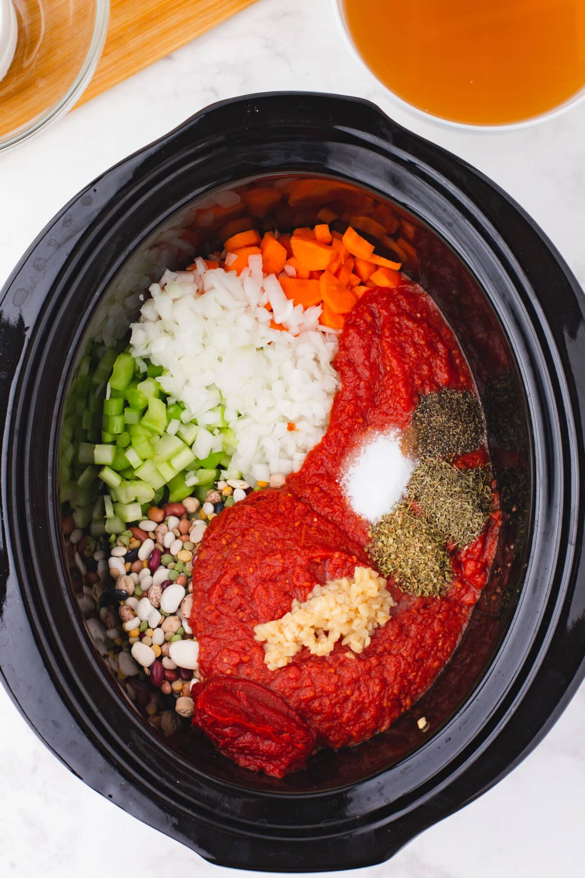 Overhead shot of 15 bean soup ingredients in a slow cooker
