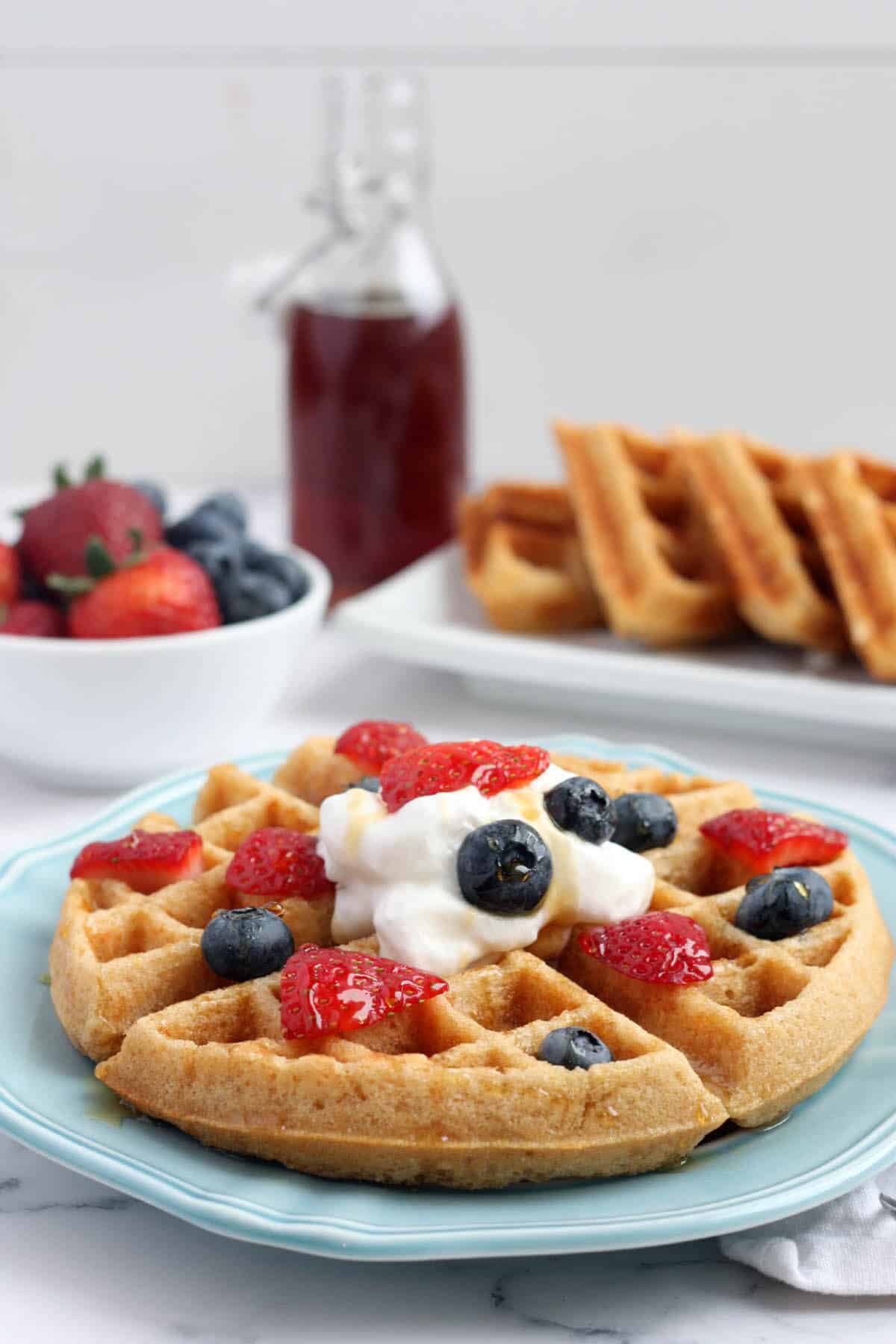 whole wheat waffles topped with whipped cream and fresh berries