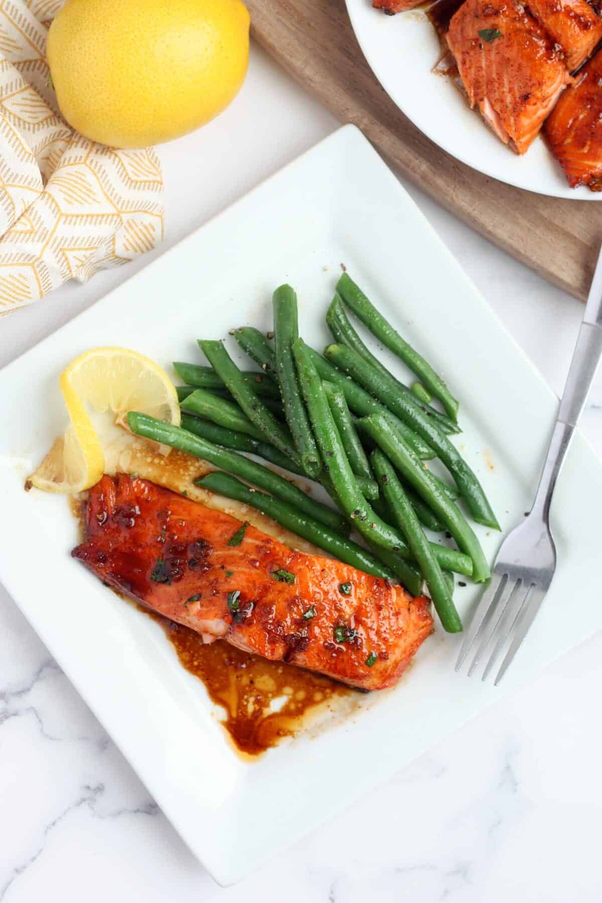 overhead view of salmon, green beans and lemon wedge