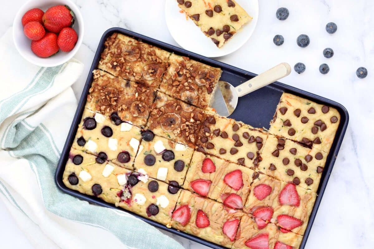 sheet pan pancakes in a blue baking sheet with assorted toppings