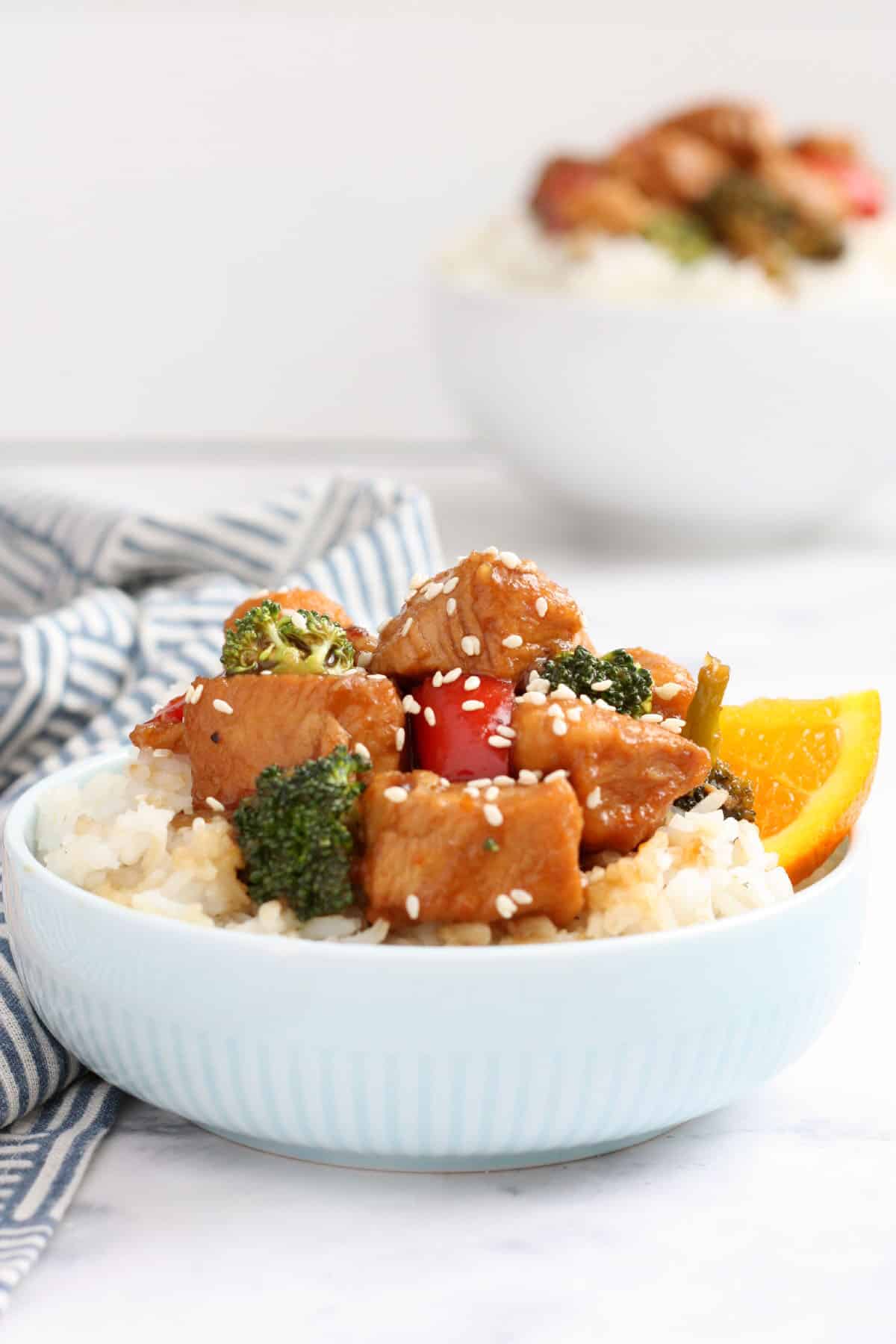 orange chicken with broccoli and peppers served over white rice