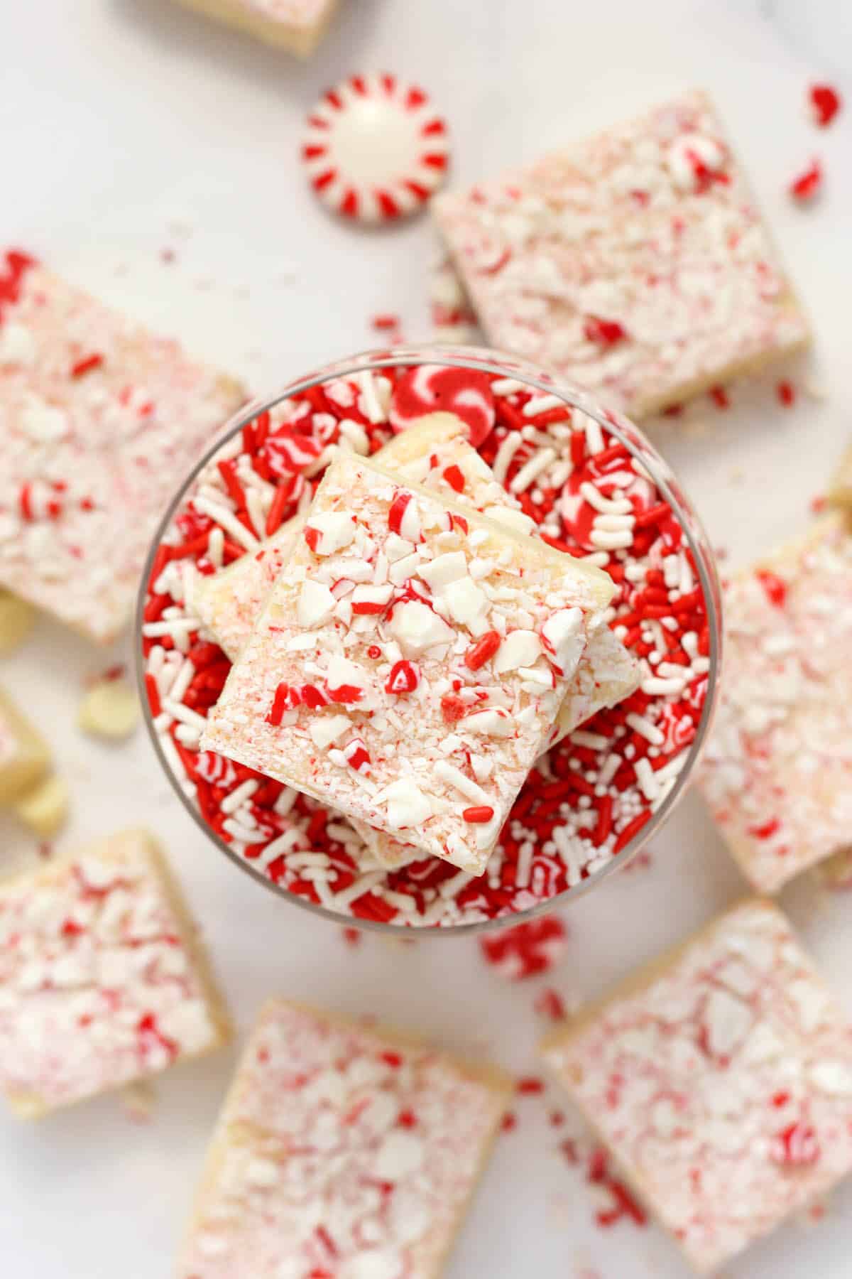 white chocolate peppermint fudge in a bowl of sprinkles