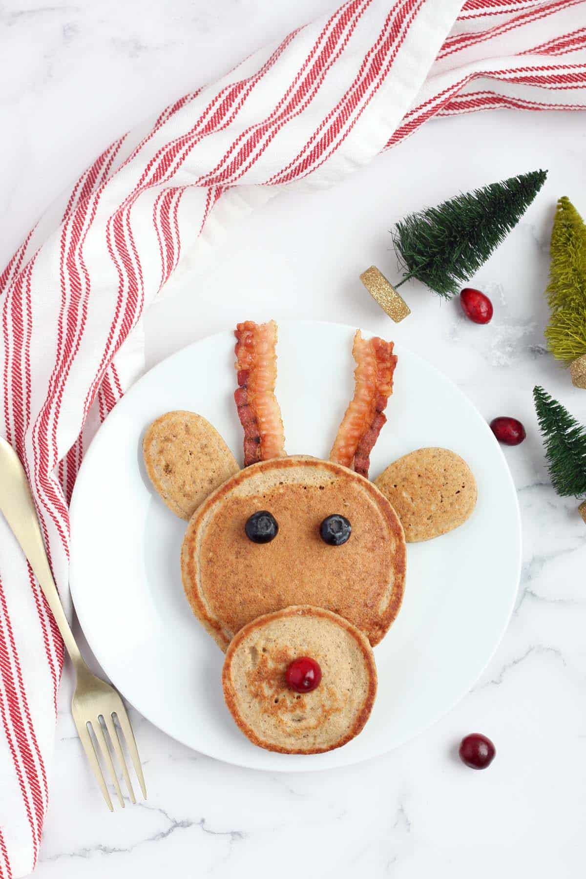 pancakes assembled to look like a reindeer with bacon for antlers