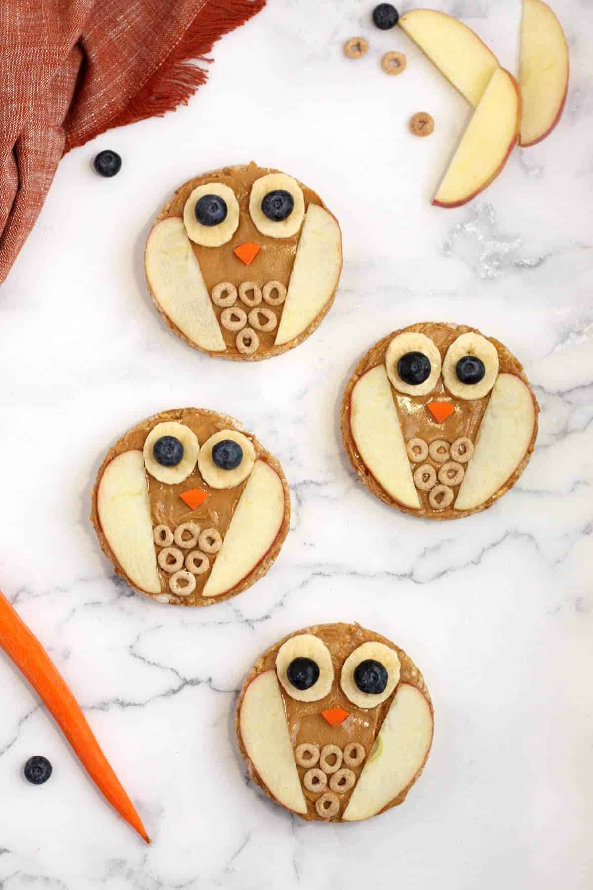 rice cakes with peanut butter and sliced fruit decorated to look like an owl