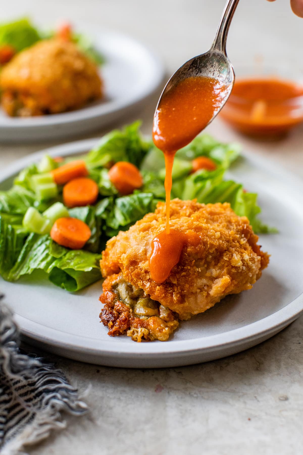 drizzling hot sauce over stuffed chicken breast