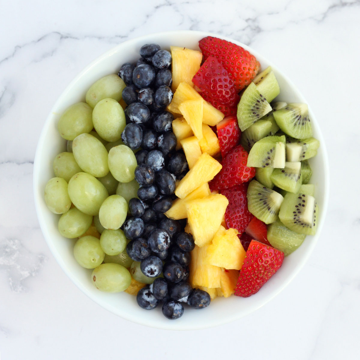 chopped fresh fruit lined up in a serving bowl