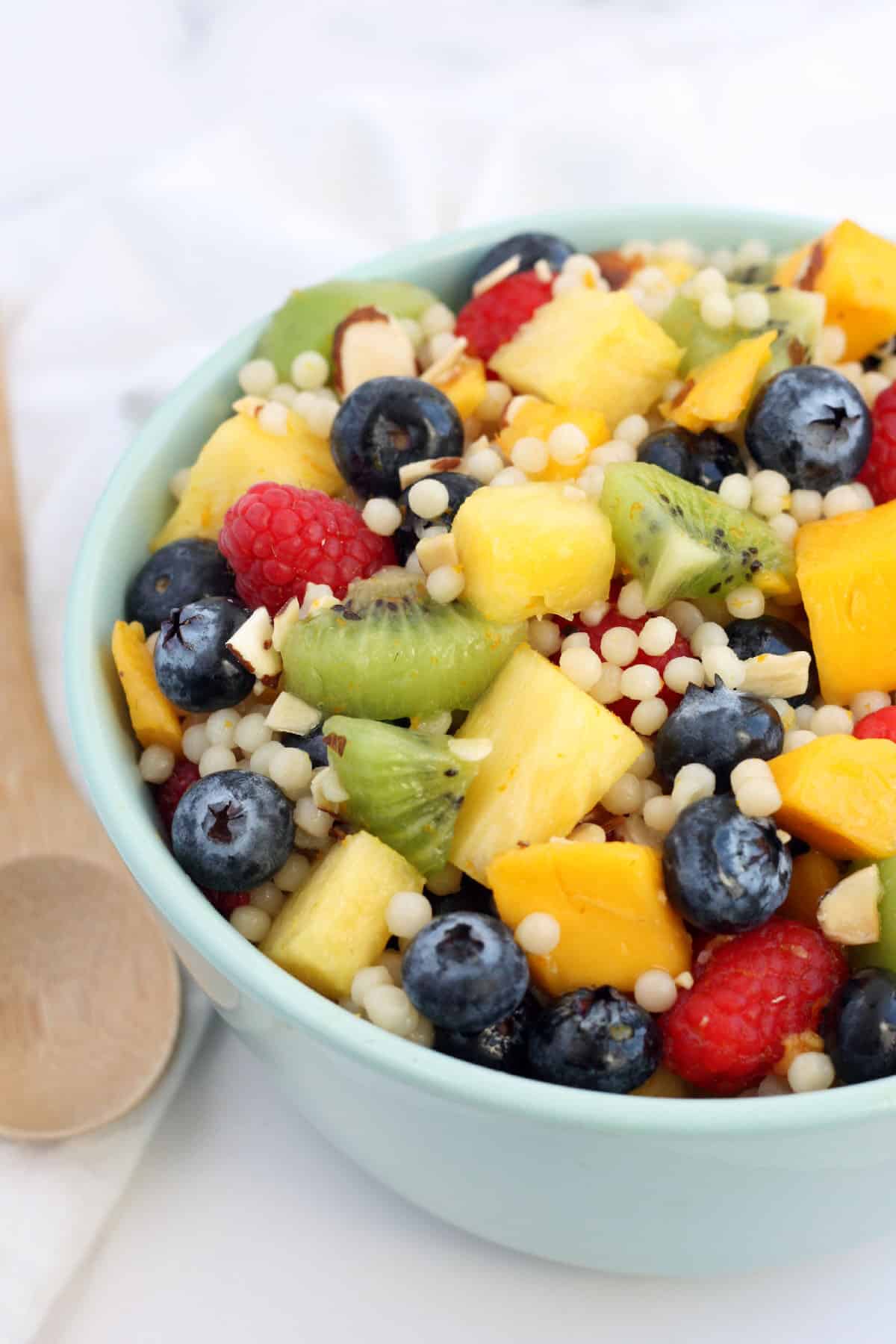 fruit salad with couscous in a blue serving bowl