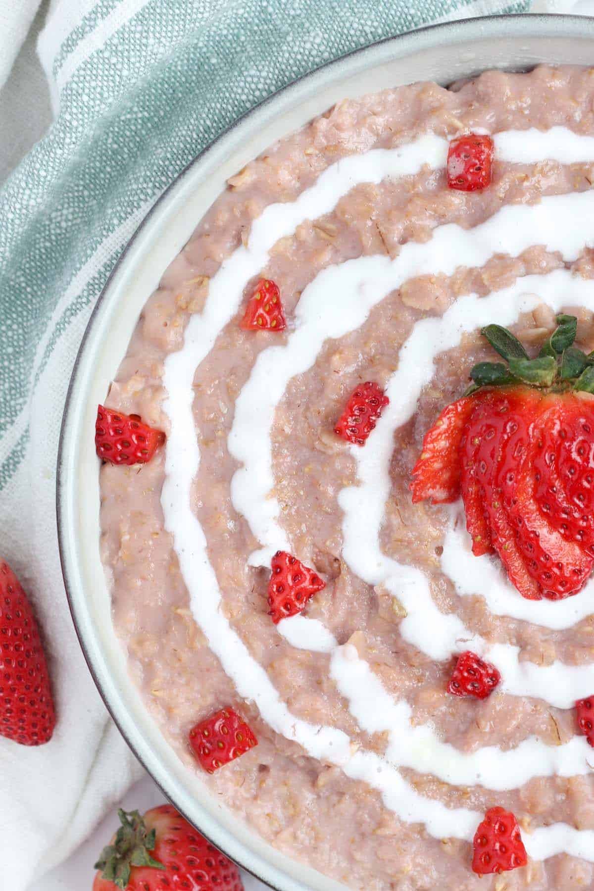 a serving of oatmeal topped with chopped strawberries and cream