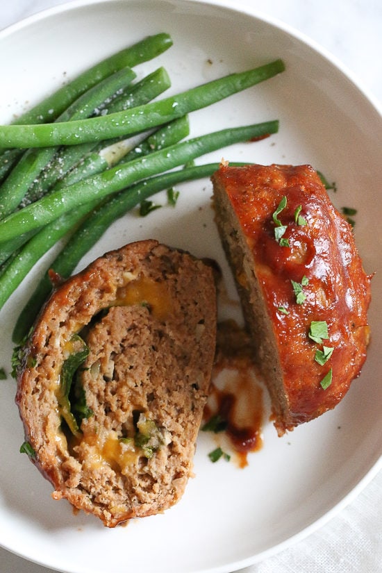 The best tasting, moist turkey meatloaf stuffed with cheddar cheese, spinach and rolled, jelly roll style topped with a ketchup based glaze.
