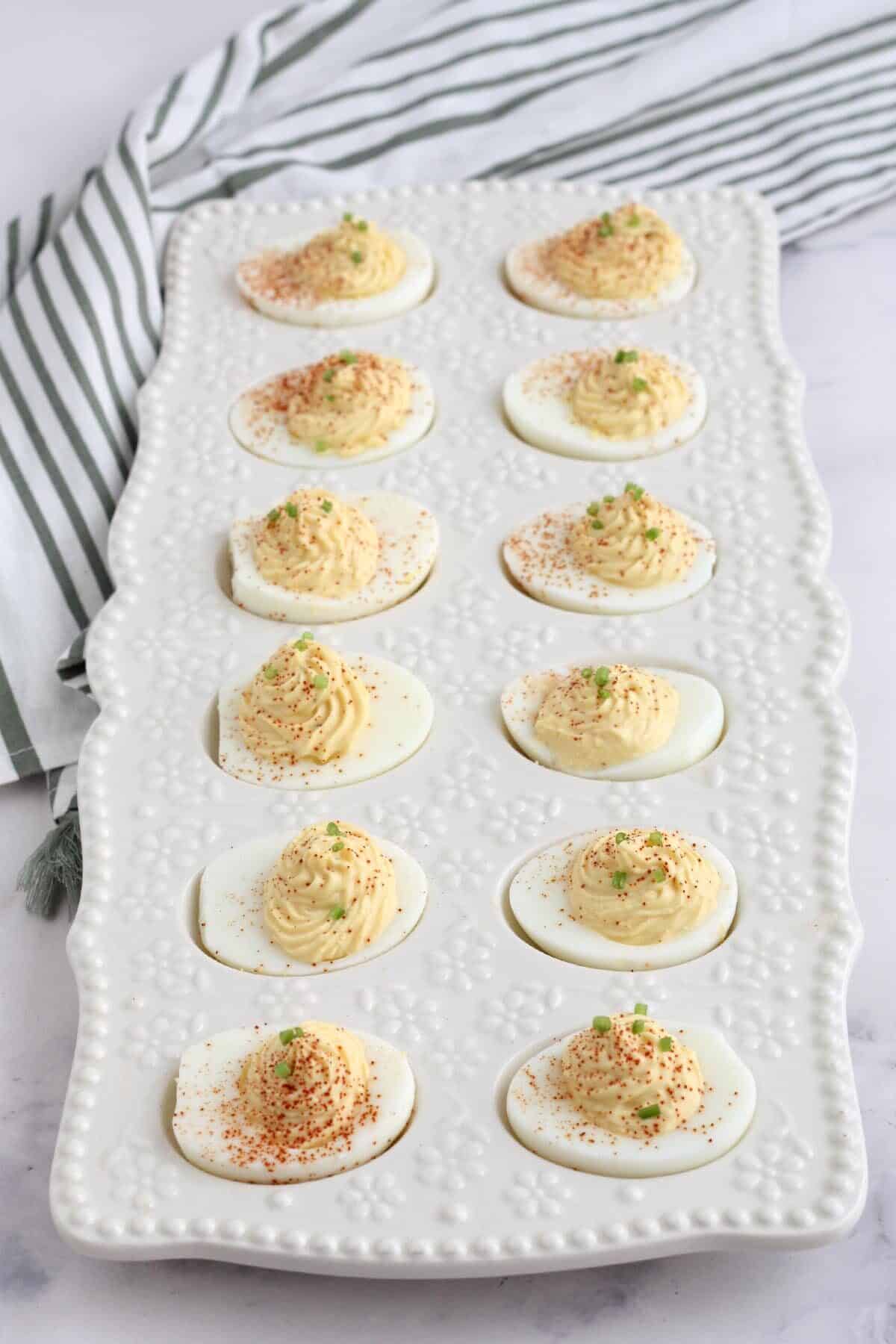 a white ceramic dish filled with deviled eggs