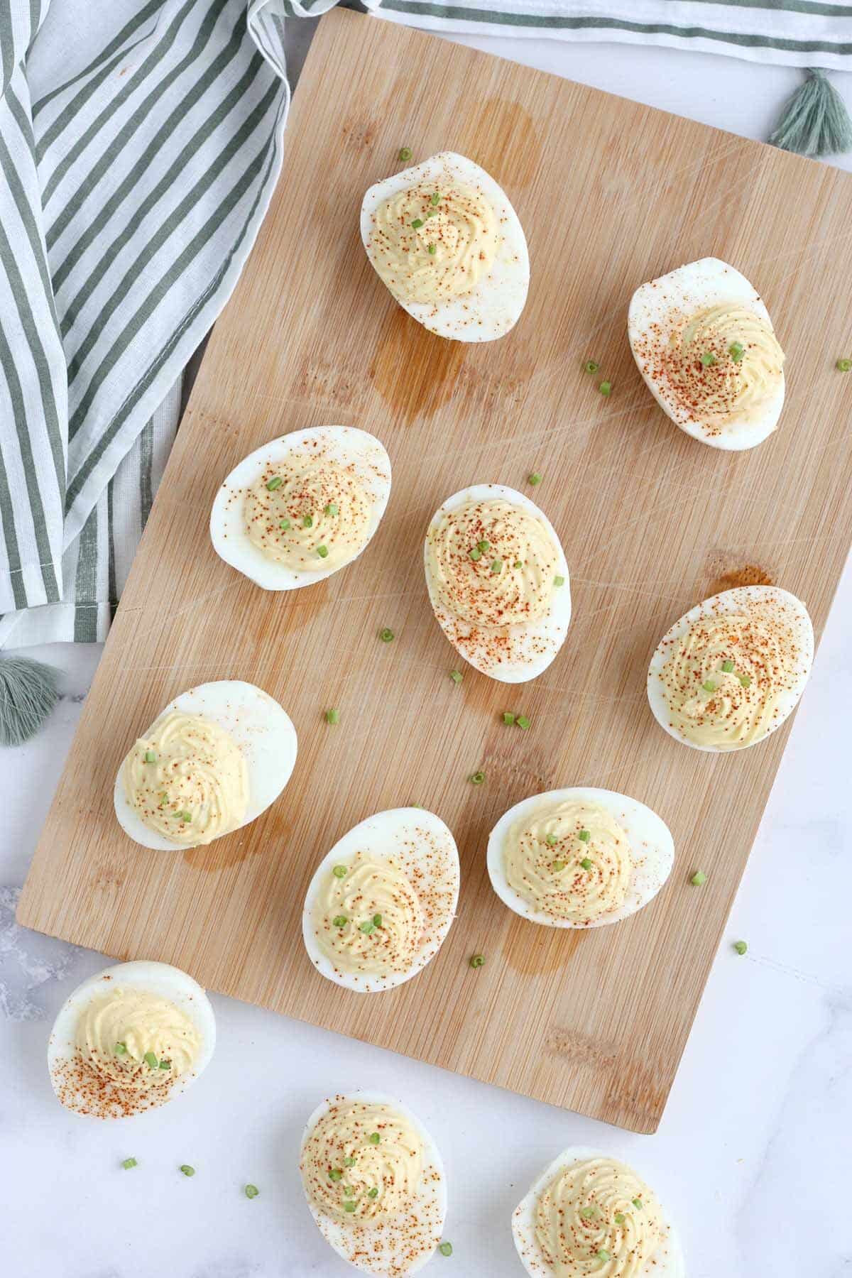 deviled eggs scattered on a wooden cutting board