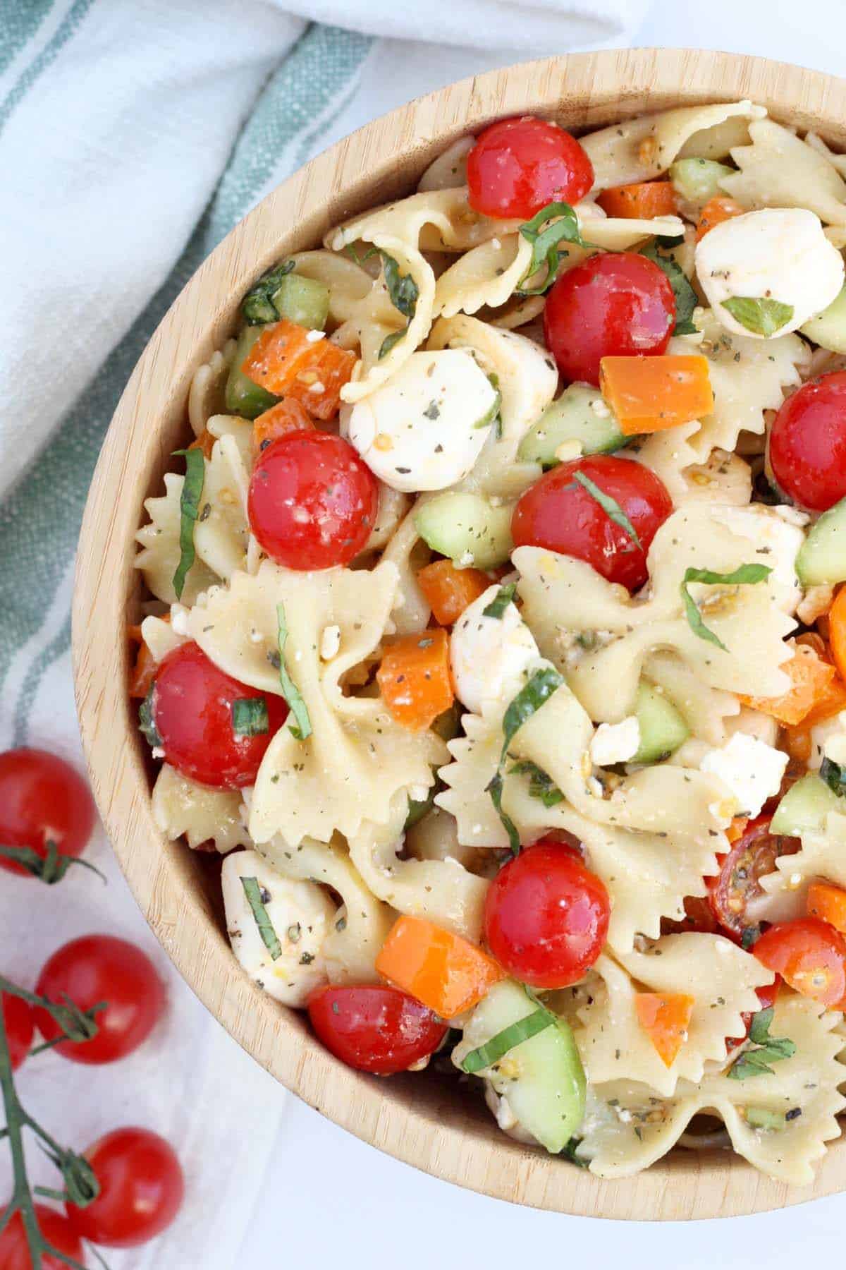 easy pasta salad with tomatoes and bell peppers in a wooden bowl