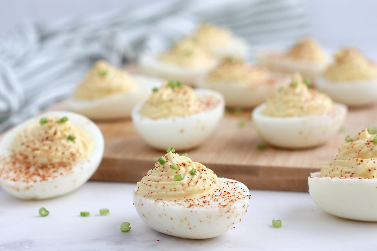 deviled eggs topped with paprika and chives