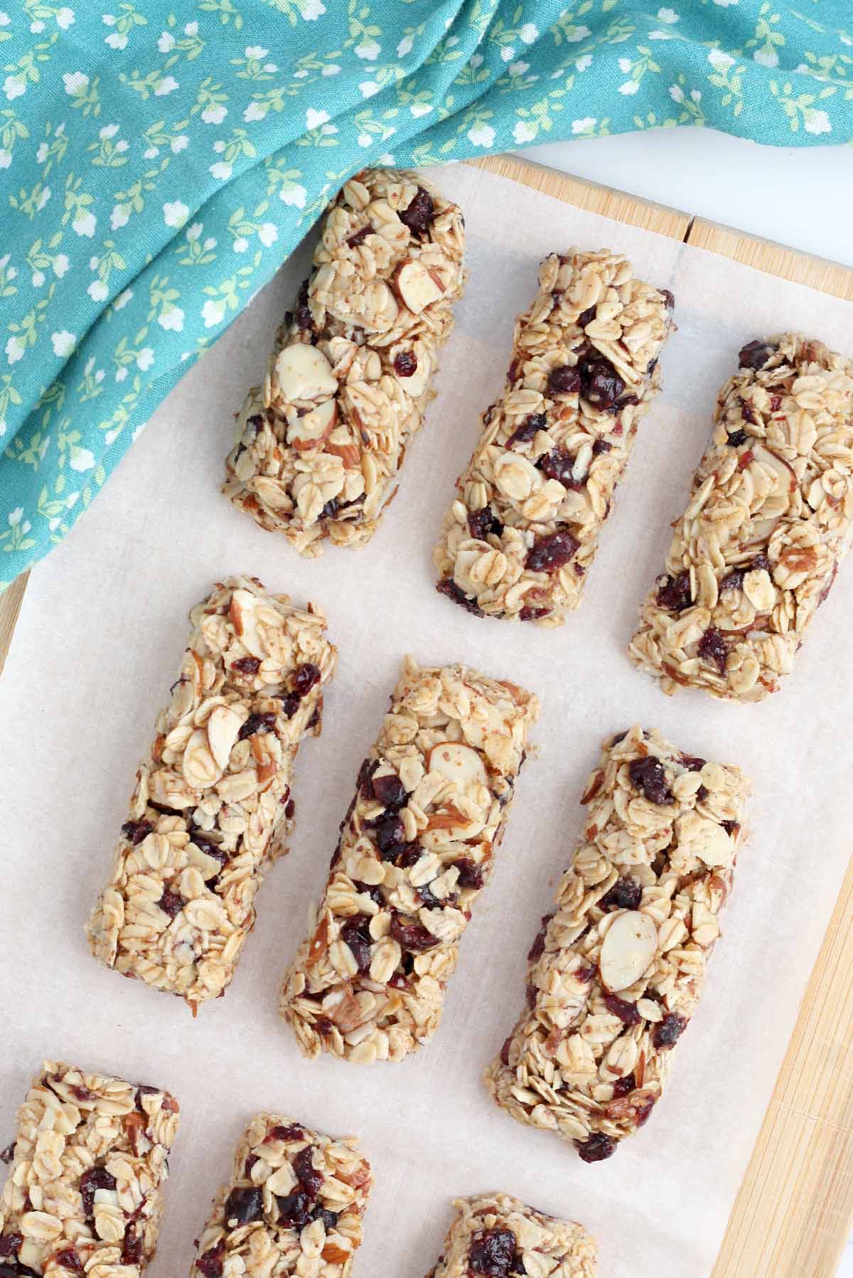 oatmeal bars lined up on parchment paper with a blue floral dish towel