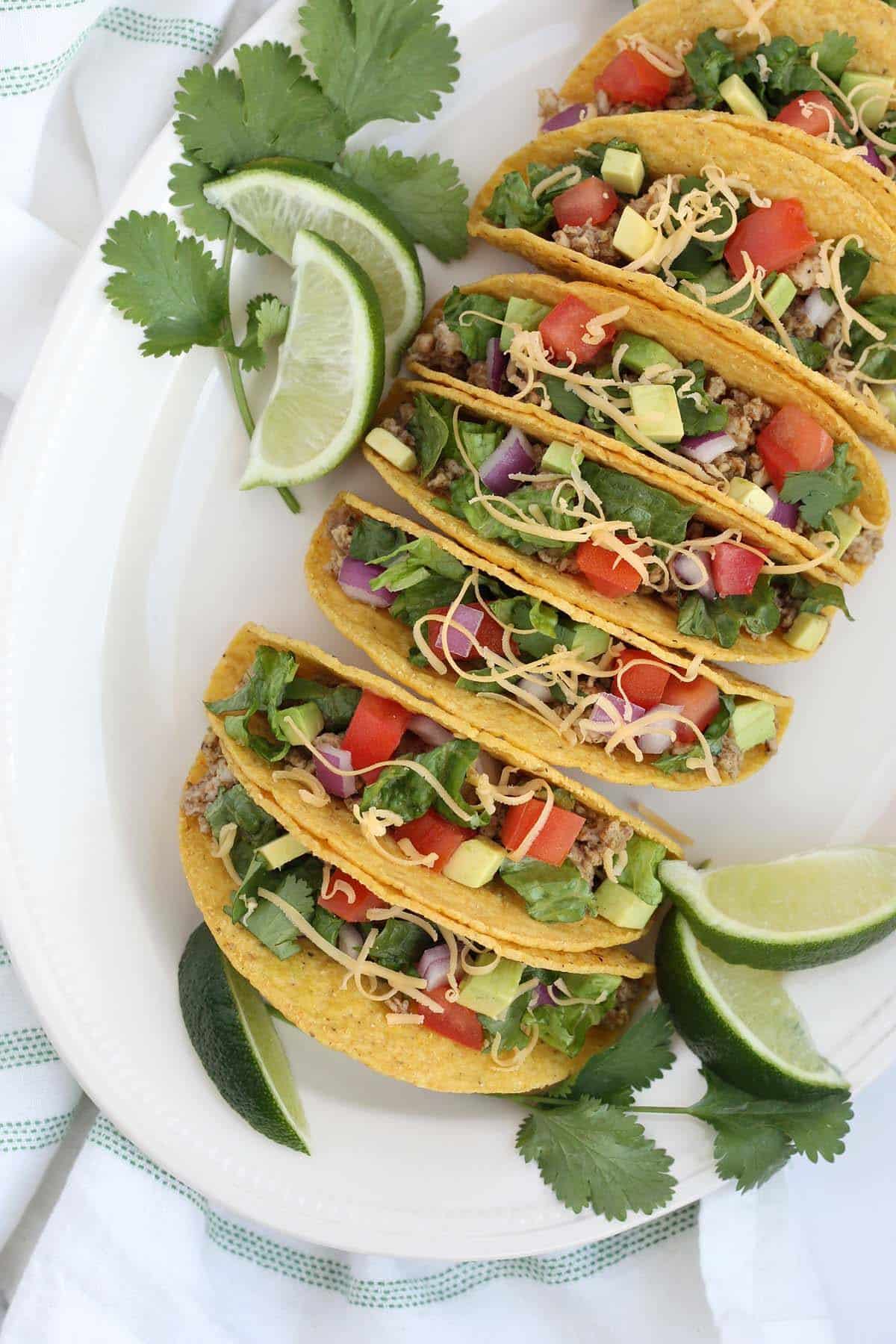 an overhead shot of ground turkey tacos topped with fresh tomatoes and avocado