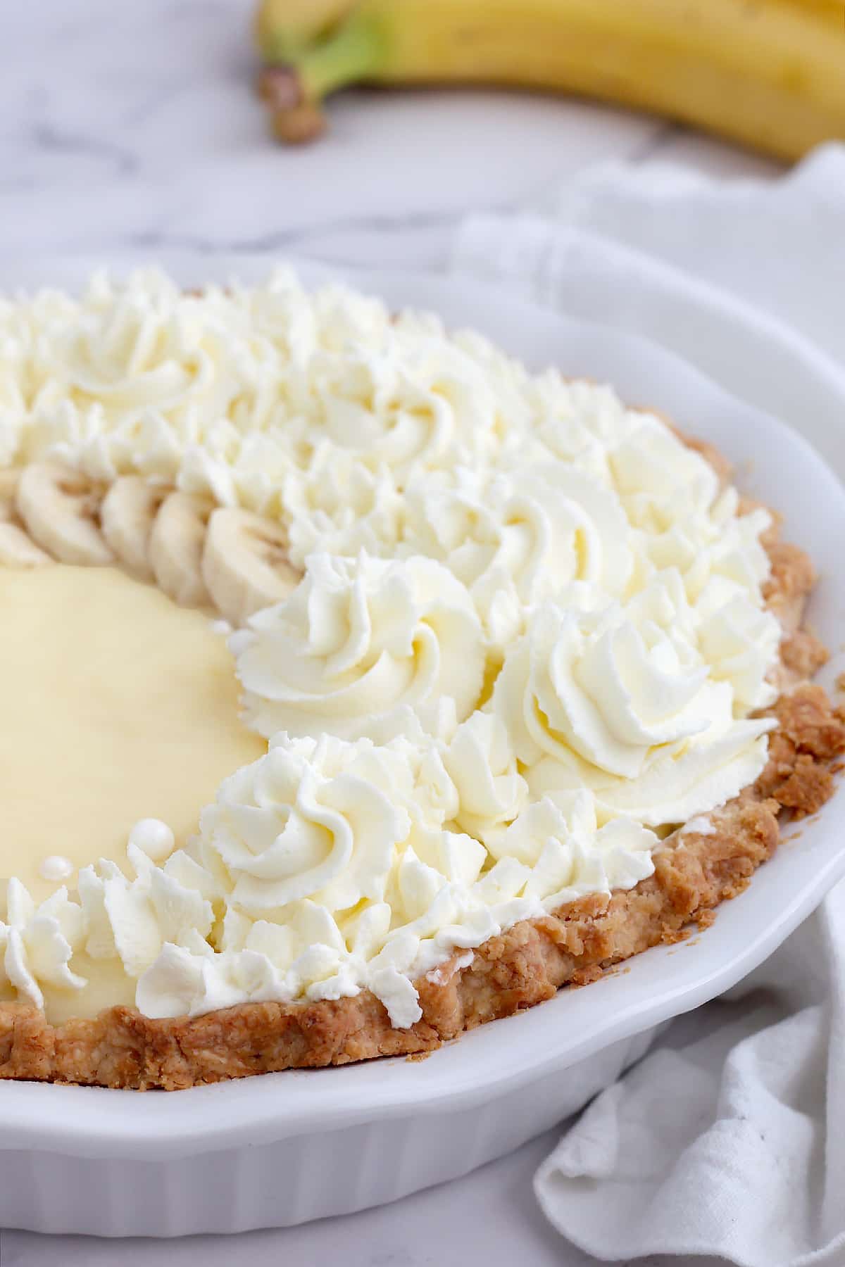 Homemade banana cream pie with whipped cream and banana slices.