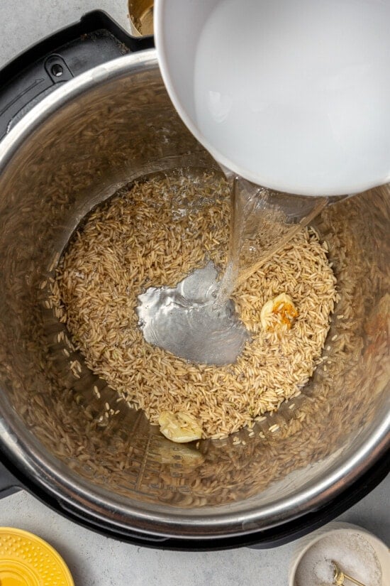 brown rice, water and garlic in pressure cooker