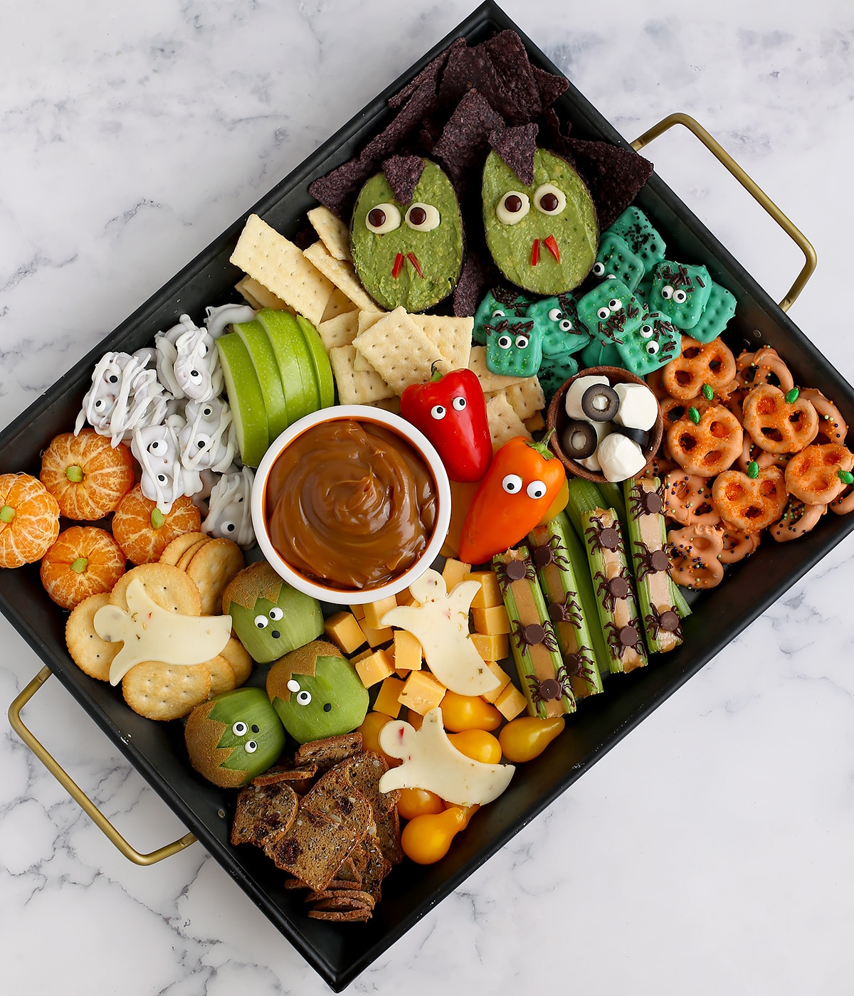 A black tray with halloween snacks.