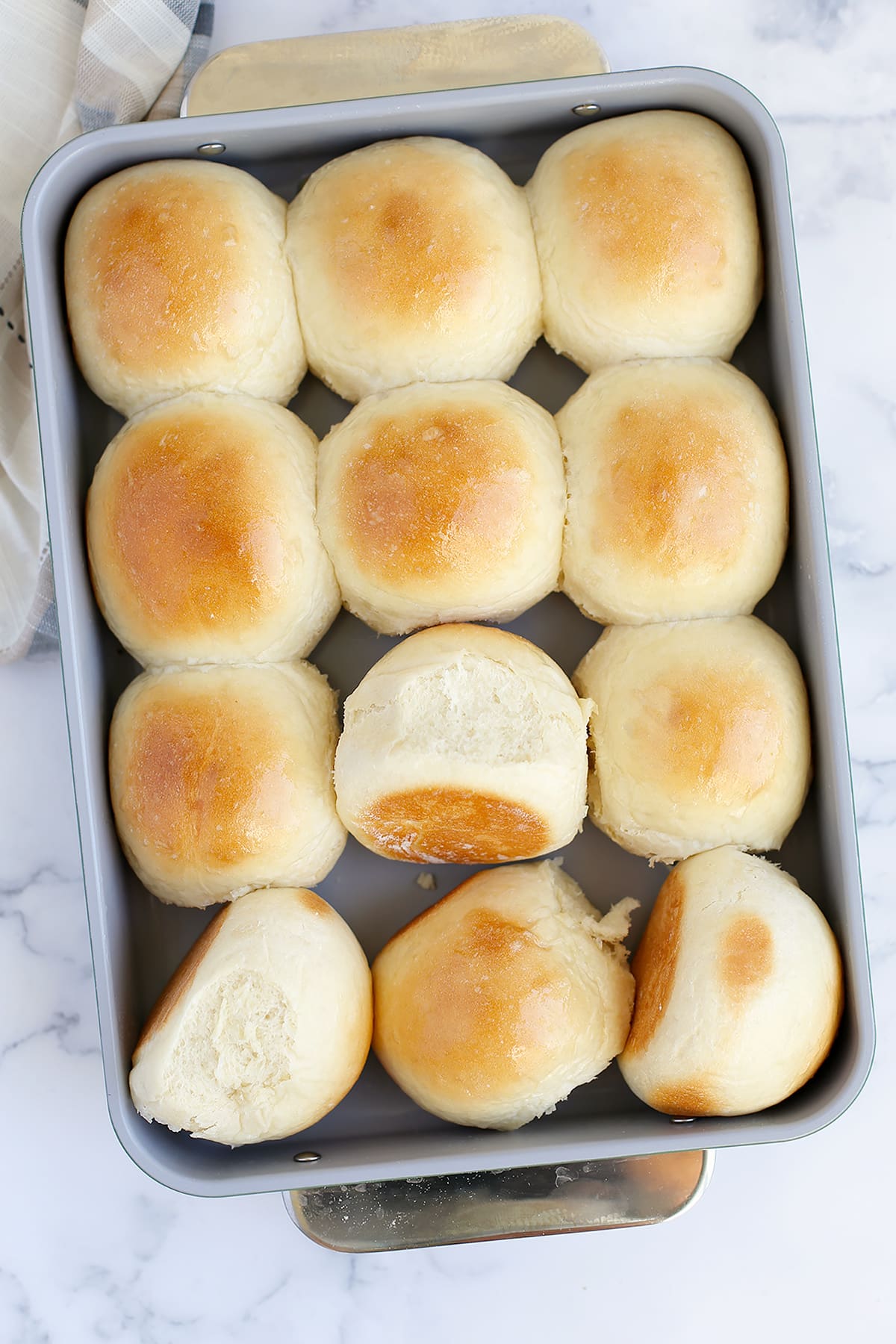 Light and fluffy homemade rolls in a gray baking dish.