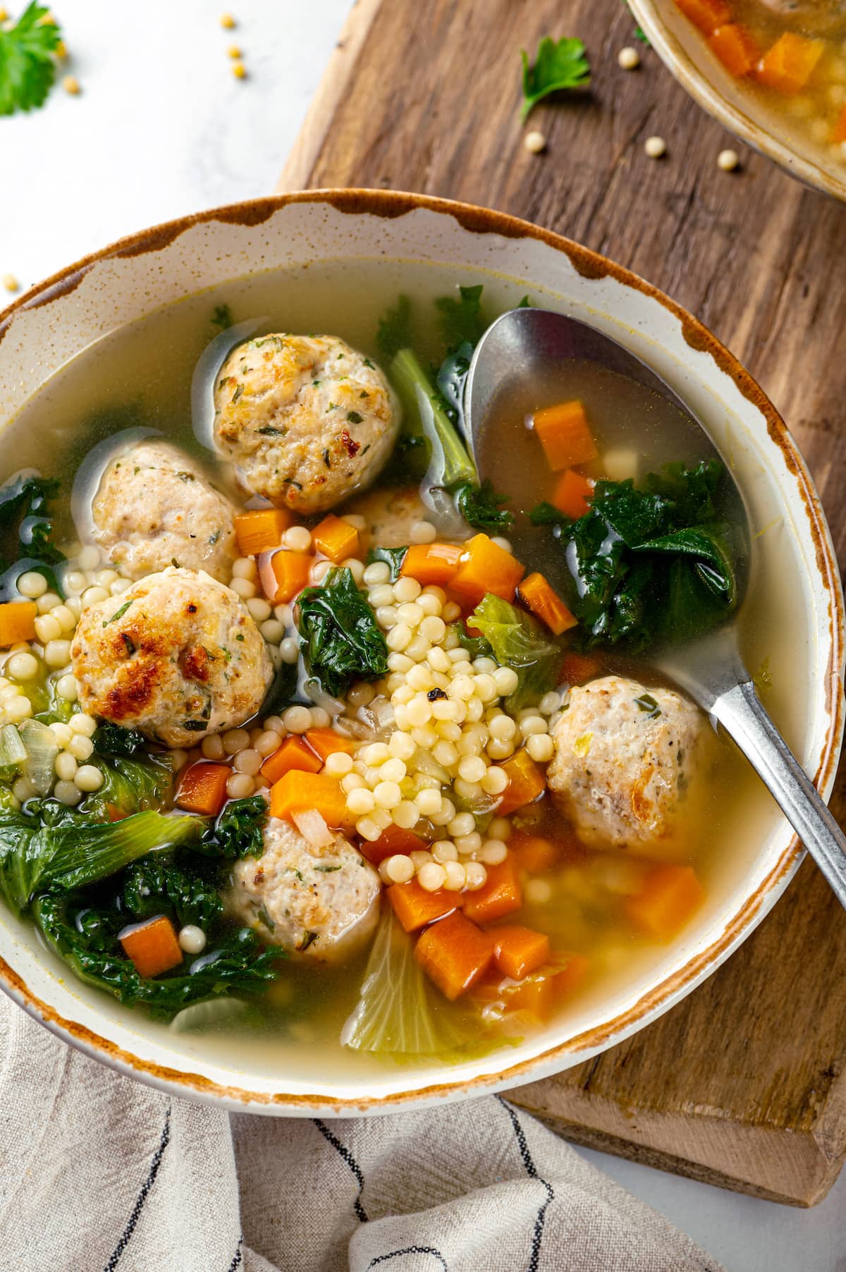 A bowl of Italian wedding soup with a spoon